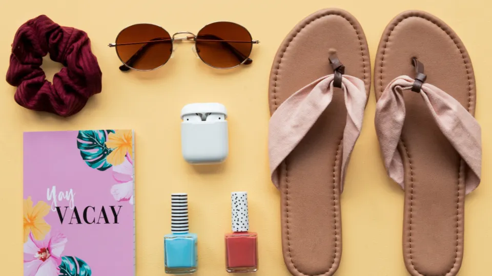 Flatlay met nagellak, een haarelastiek en een notitieboekje op geel